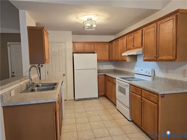 a kitchen with a sink refrigerator and cabinets