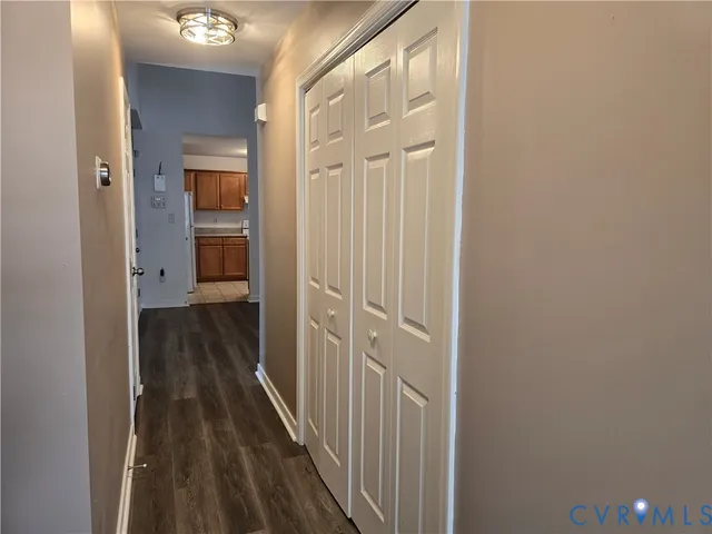 a view of a hallway with wooden floor and a bathroom