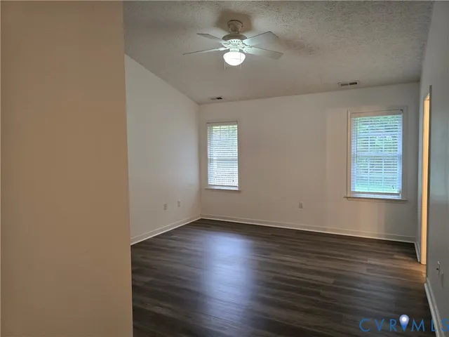 a view of wooden floor and a chandelier fan in a room