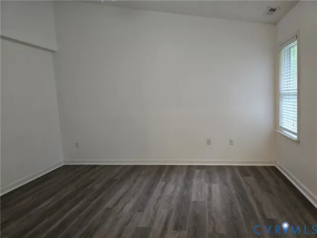 a view of a room with wooden floor and a window