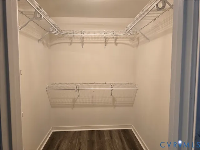 a view of walk in closet with racks on the wall