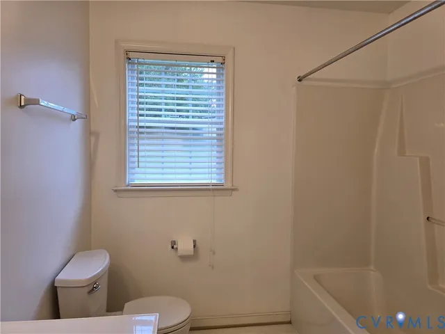 a white toilet sitting next to a bath tub