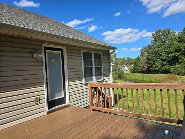 a view of a wooden deck and a backyard