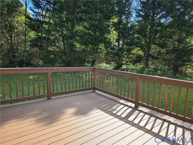 a view of deck with wooden floor and fence next to a yard