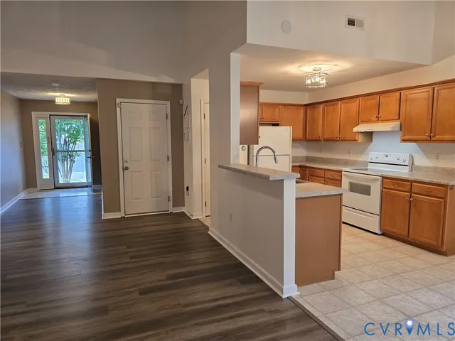 a kitchen with wooden floors and white cabinets