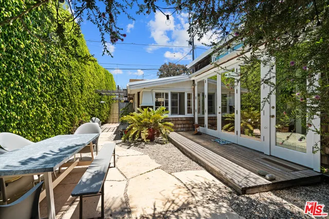 a view of a patio with table and chairs and floor to ceiling window