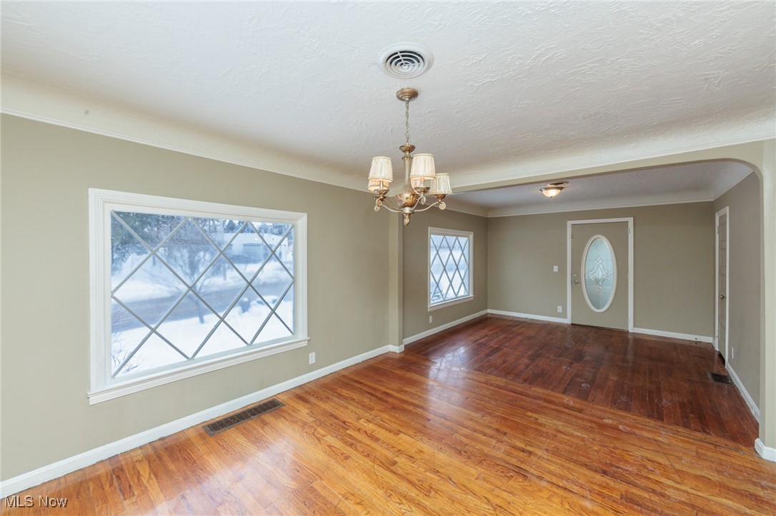 5062 Lee Road Maple Heights, OH 44137 - Photo 5 of 50 Entrance foyer with wood-type flooring, a chandelier, a textured ceiling, and arched walkways