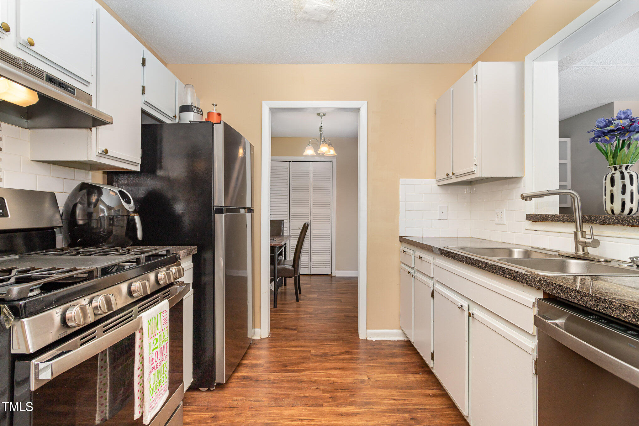 5816 Pointer Drive, Unit 102 Raleigh, NC 27609 - Photo 13 of 25 a kitchen with stainless steel appliances granite countertop a stove a sink and a refrigerator