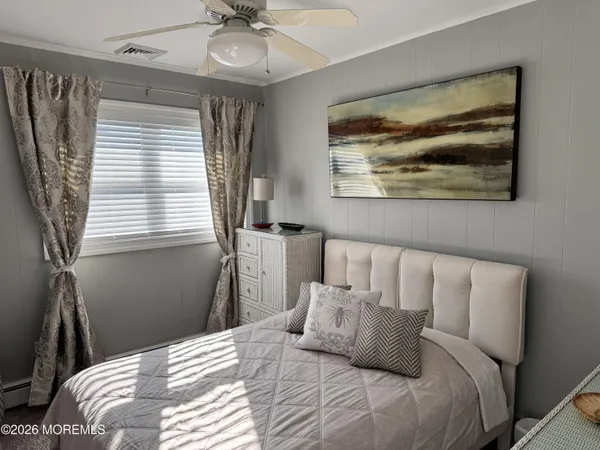 a bedroom with a bed and a painting on the wall