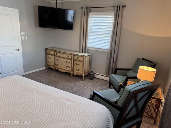 a bedroom with furniture and a flat screen tv