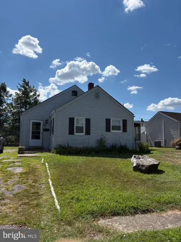 a house view with a sitting space fire pit and outdoor space