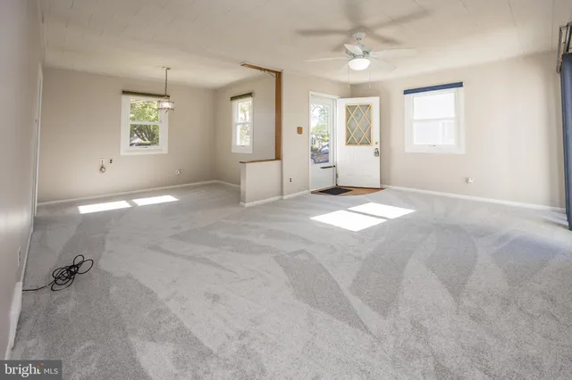 an empty room with windows and cabinet