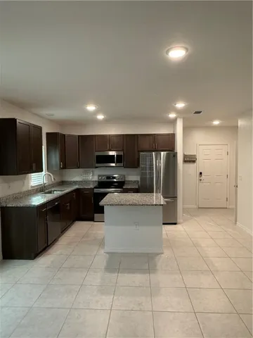 a large kitchen with stainless steel appliances and a refrigerator