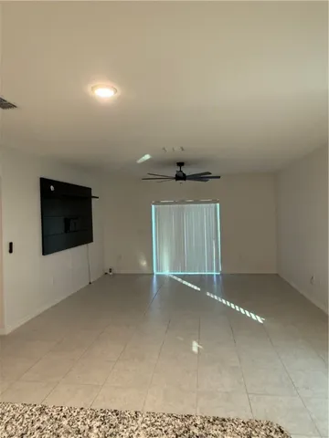 a view of an empty room with a fireplace and a window