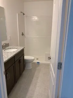 a bathroom with a granite countertop sink a toilet and shower