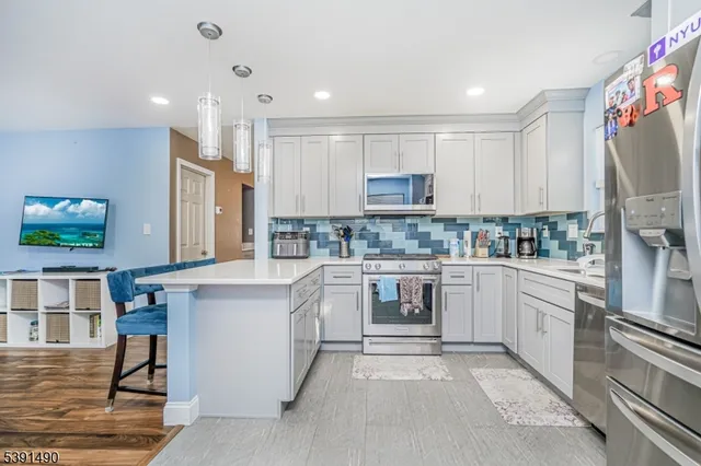a kitchen with stainless steel appliances granite countertop a refrigerator sink and cabinets