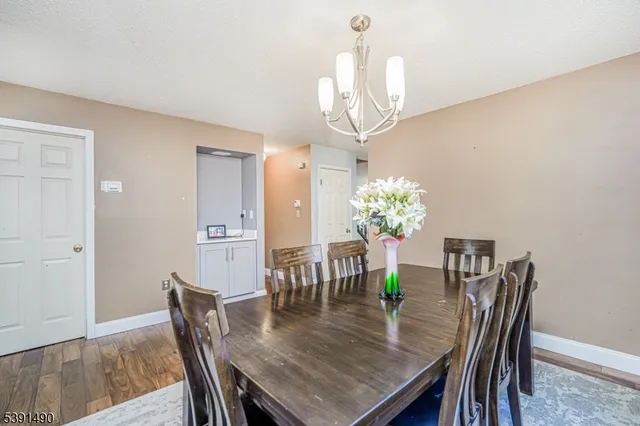 a view of a dining room with furniture a chandelier and wooden floor