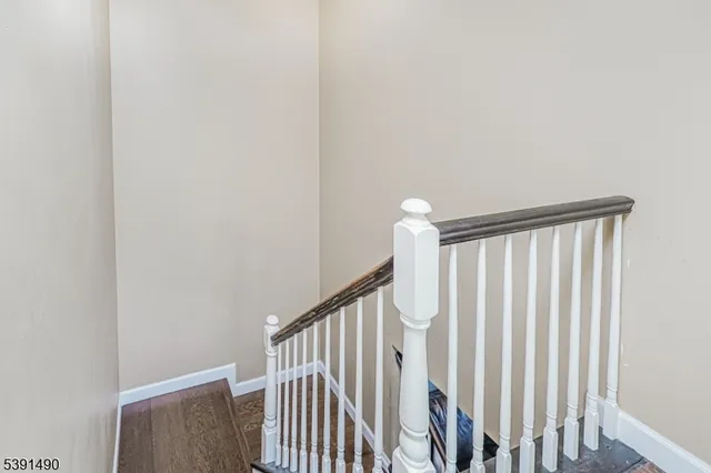 a view of staircase with railing and white walls