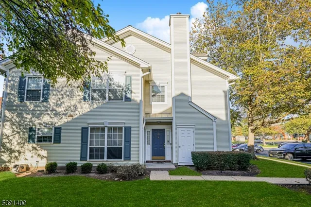 a view of a yard in front of a house with plants and large tree