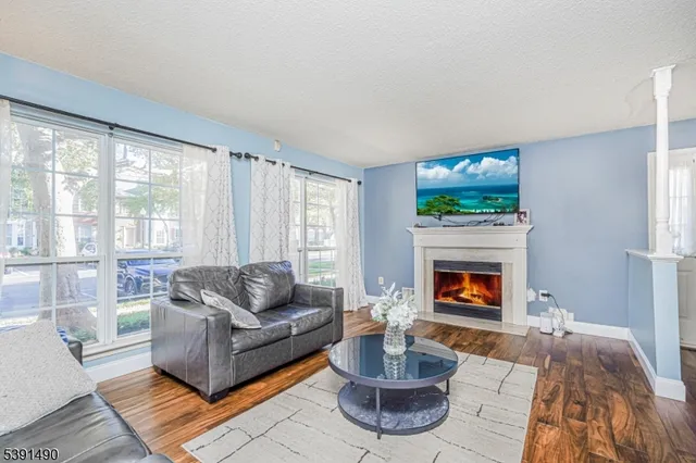 a living room with furniture a flat screen tv and a fireplace