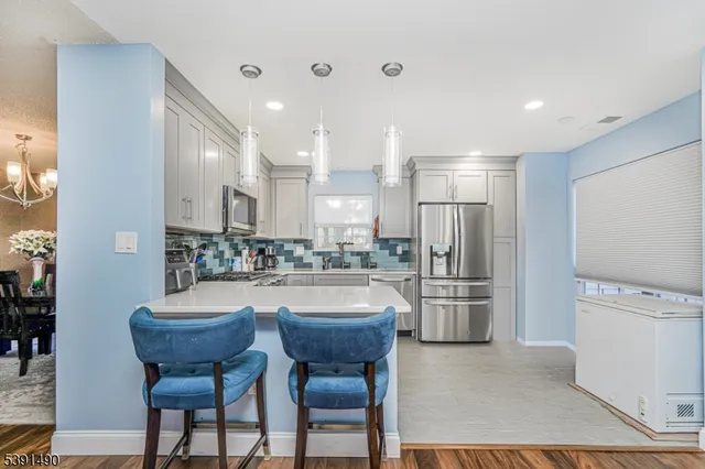 a kitchen with refrigerator and chairs