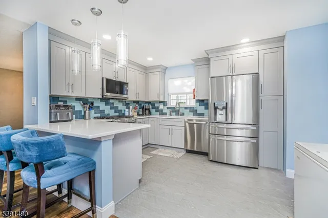 a kitchen with stainless steel appliances granite countertop a refrigerator sink and stove