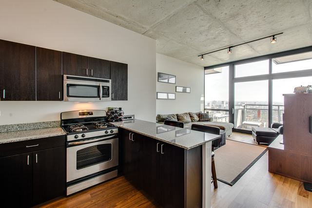 235 West Van Buren Street, Unit 4111 Chicago, IL 60607 - Photo 2 of 15 a kitchen with a stove a sink and a microwave