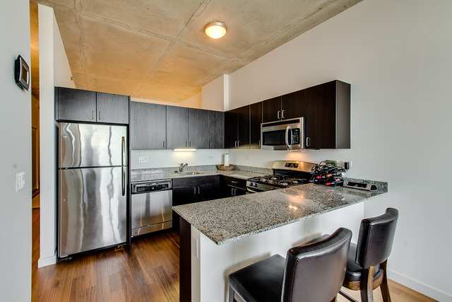 235 West Van Buren Street, Unit 4111 Chicago, IL 60607 - Photo 3 of 15 a kitchen with stainless steel appliances granite countertop a stove refrigerator and microwave