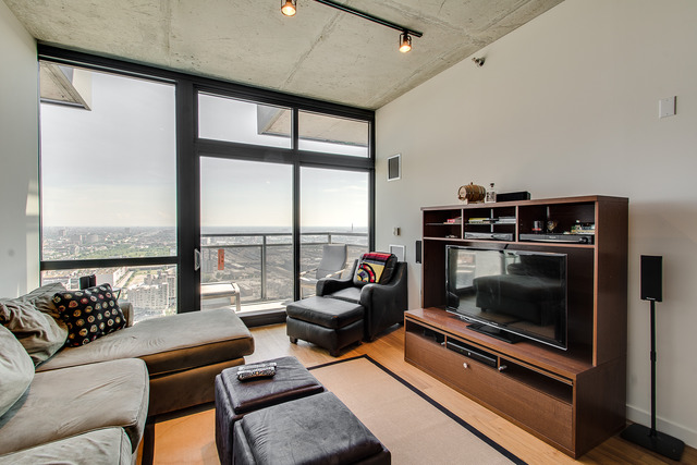 235 West Van Buren Street, Unit 4111 Chicago, IL 60607 - Photo 5 of 15 a living room with furniture and a floor to ceiling window