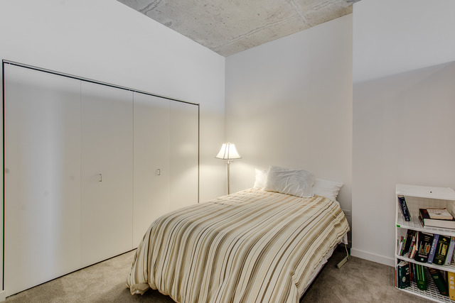 235 West Van Buren Street, Unit 4111 Chicago, IL 60607 - Photo 9 of 15 a bedroom with a bed and a book shelf