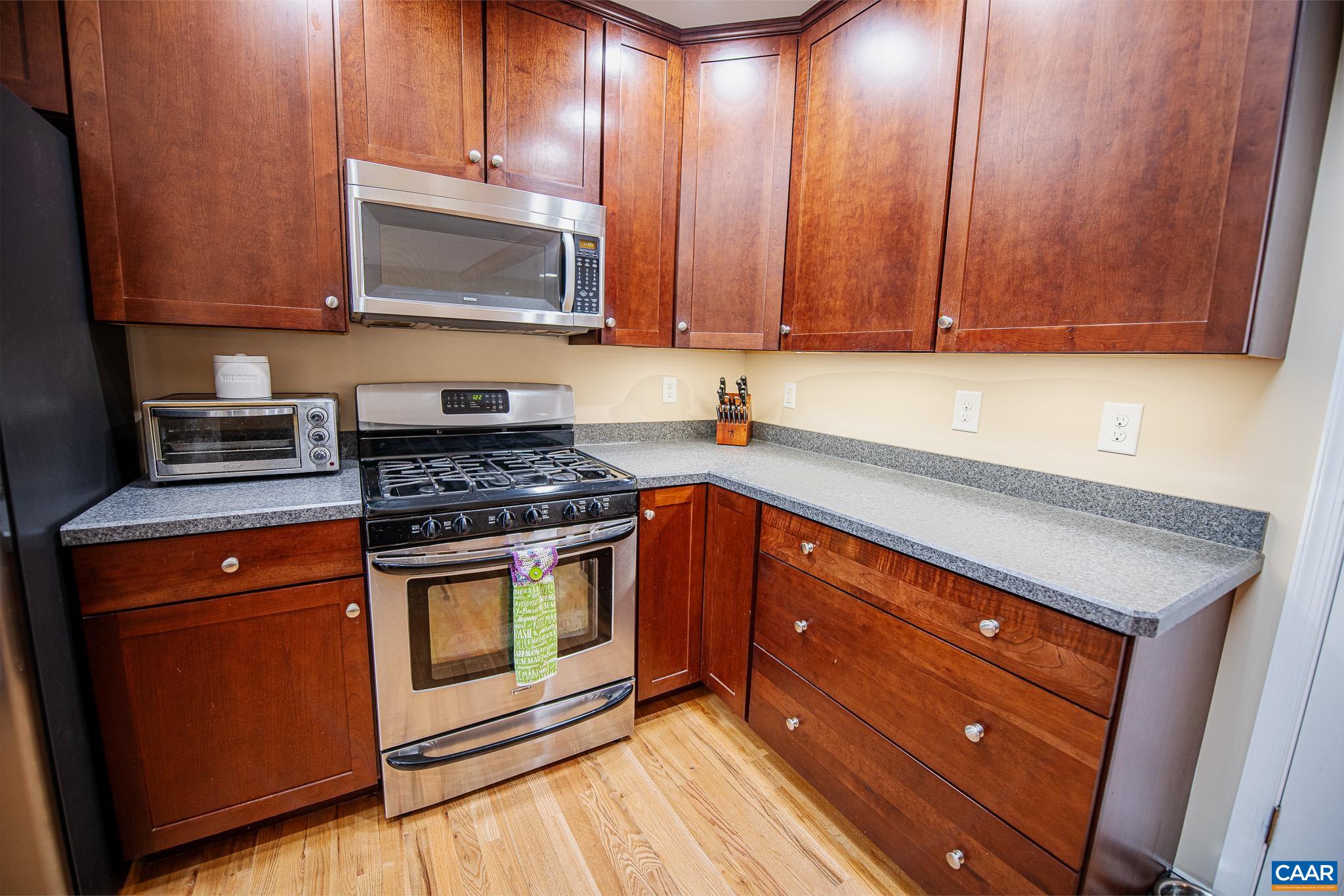 1101 Keith Road Stanardsville, VA 22973 - Photo 18 of 38 a kitchen with granite countertop wooden cabinets and a stove top oven