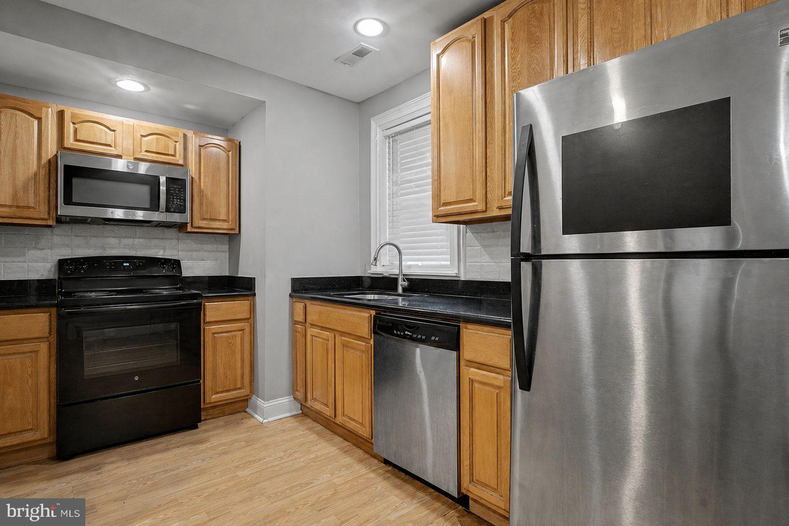 1936 North 7th Street, Unit 2 Philadelphia, PA 19122 - Photo 5 of 12 a kitchen with stainless steel appliances granite countertop a refrigerator and a stove top oven