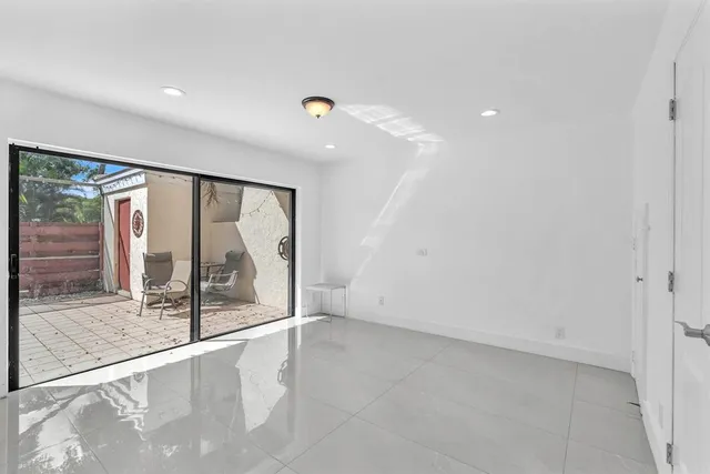 a view of an empty room with wooden floor and a fireplace