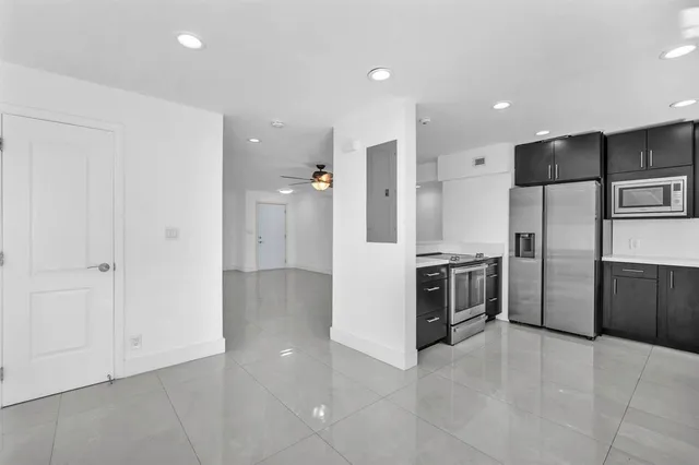 a large kitchen with a refrigerator and a sink