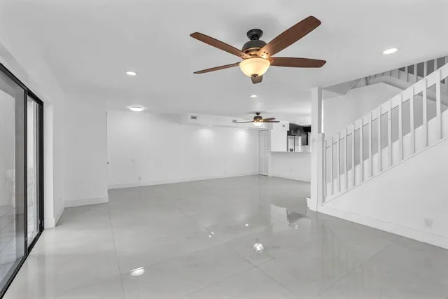 an empty room with a ceiling fan and a window