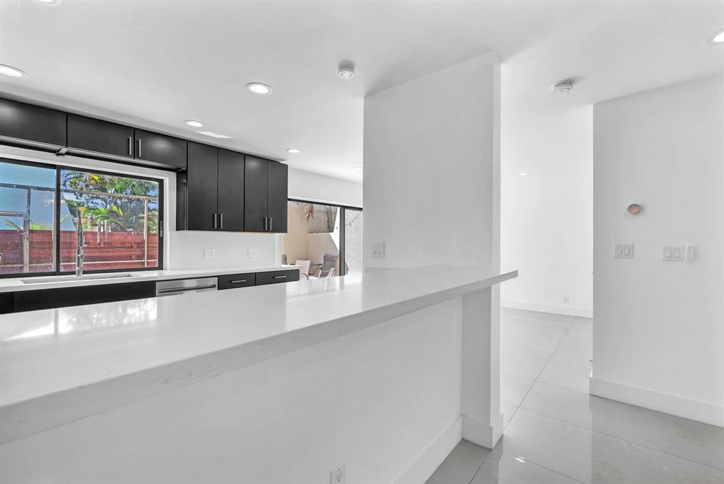 3896 Meadow Lane Hollywood, FL 33021 - Photo 10 of 33 a large white kitchen with stainless steel appliances a large counter top a stove and a refrigerator