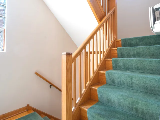 a view of staircase with wooden floor and white walls