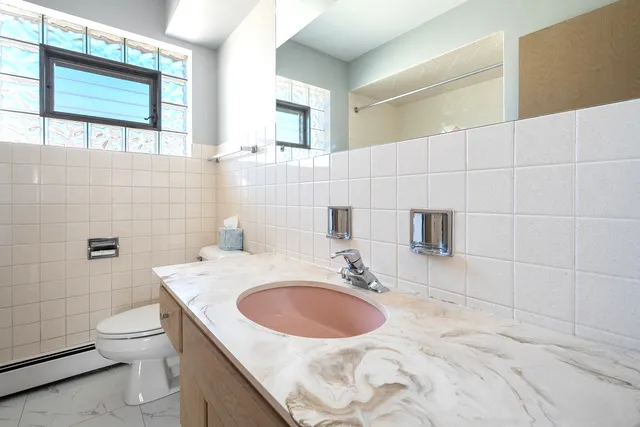 a bathroom with a sink toilet and mirror