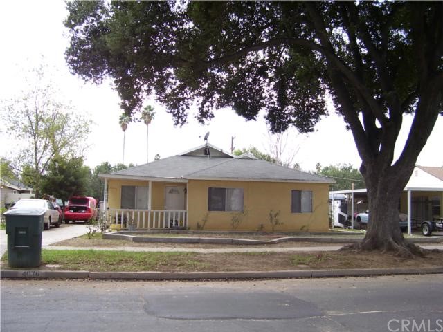 4076 Canterbury Road Riverside, CA 92504 - Photo 1 of 1 a front view of a house with a garden and tree