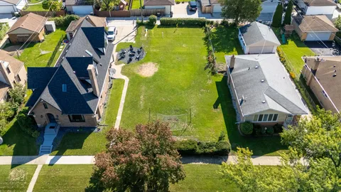 an aerial view of residential house with outdoor space and a swimming pool