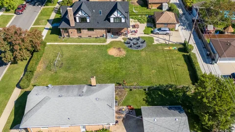 an aerial view of a house with garden space and a building