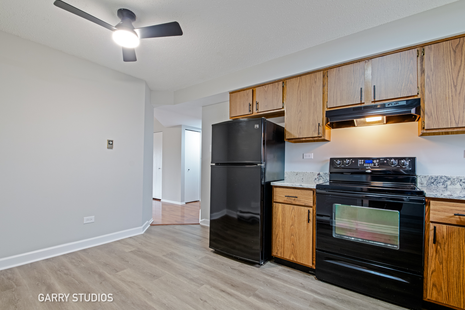 720 Briar Hill Lane, Unit 5 Addison, IL 60101 - Photo 3 of 14 a kitchen with a refrigerator stove and wooden cabinets