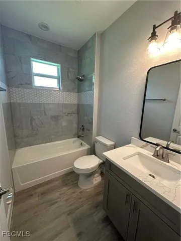 a bathroom with a sink a toilet a mirror and bathtub