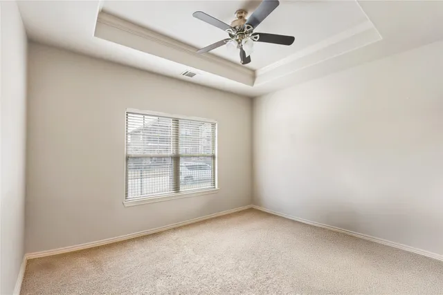 an empty room with a window and a fan