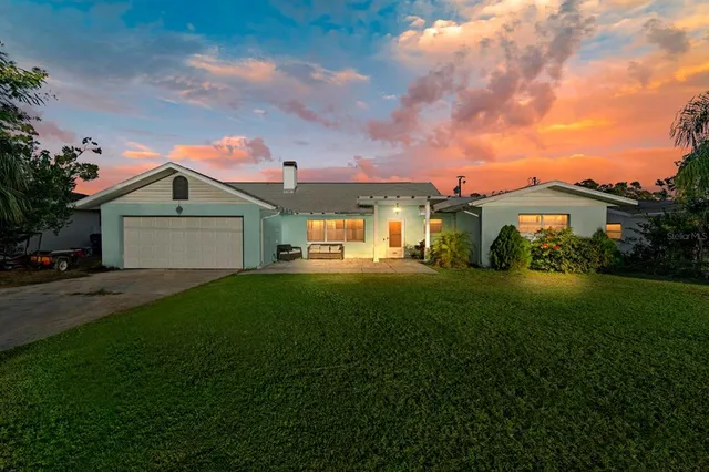 a front view of a house with a garden and yard