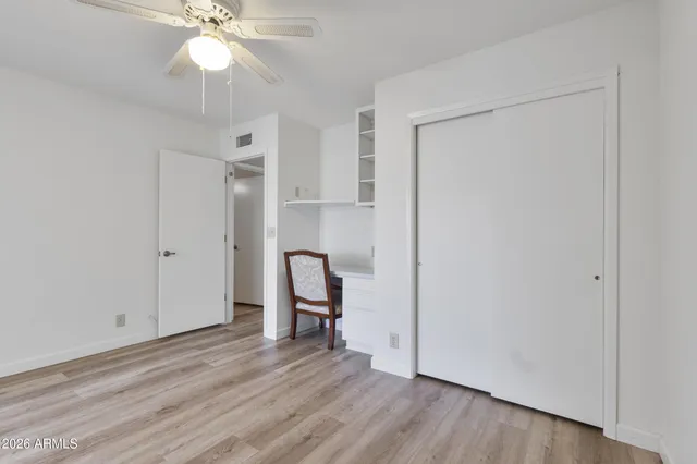a view of a room with wooden floor fan and windows
