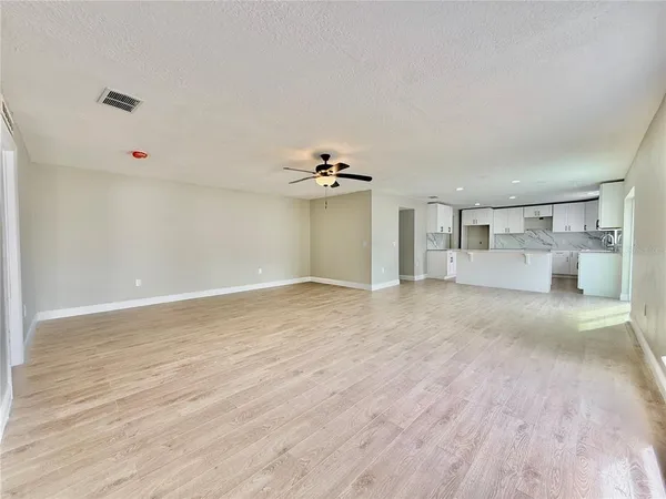 a kitchen with granite countertop white cabinets white appliances a sink and a window