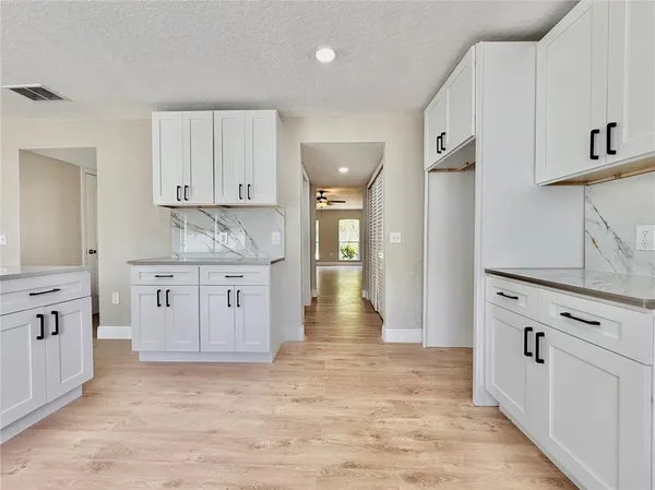 a kitchen with kitchen island white cabinets and refrigerator