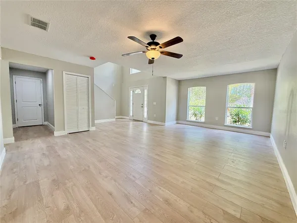 a view of a livingroom with wooden floor and a ceiling fan