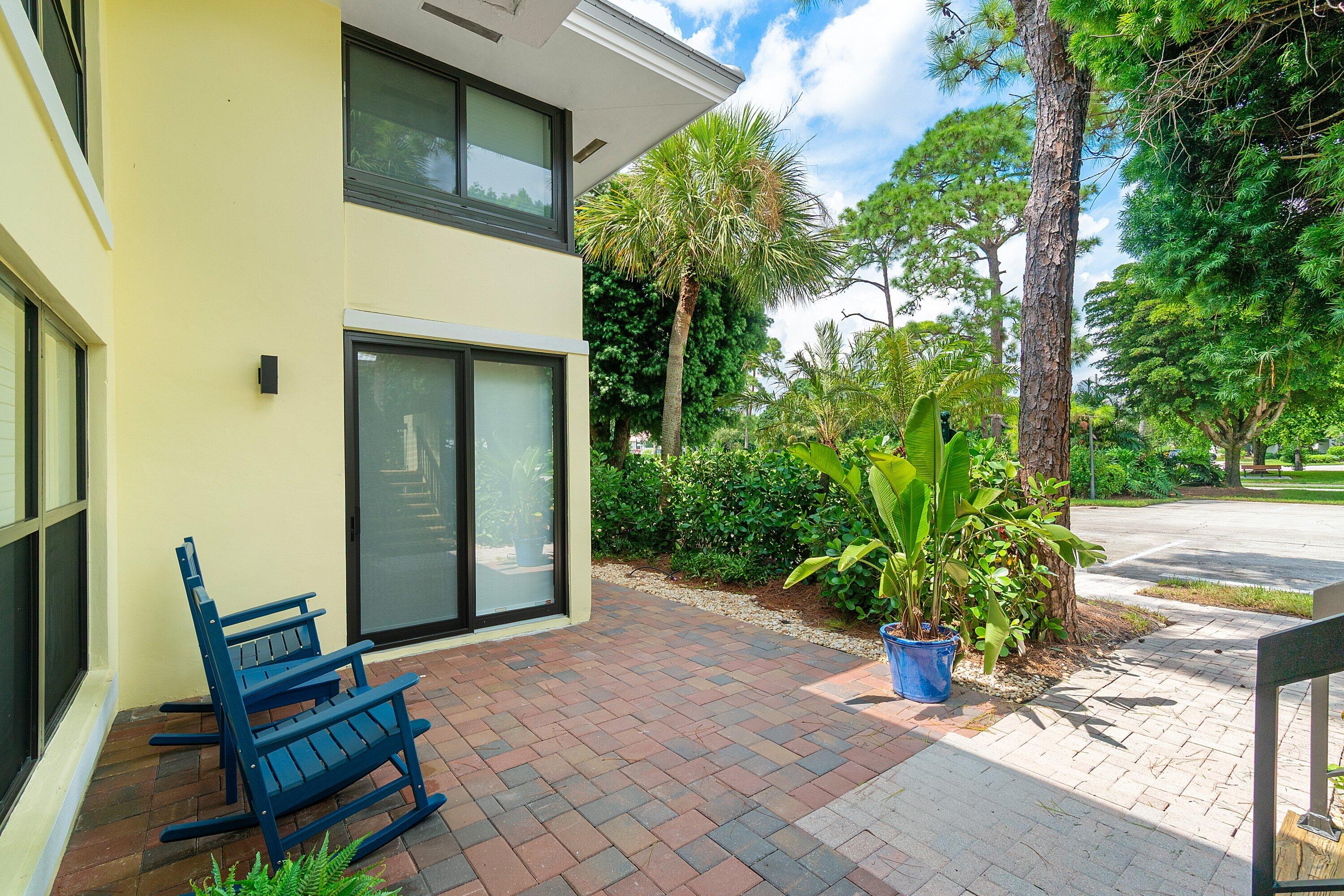 3709 North Quail Ridge Drive, Unit BOBWHITE B Boynton Beach, FL 33436 - Photo 40 of 51 a view of a chair and table in the backyard of the house